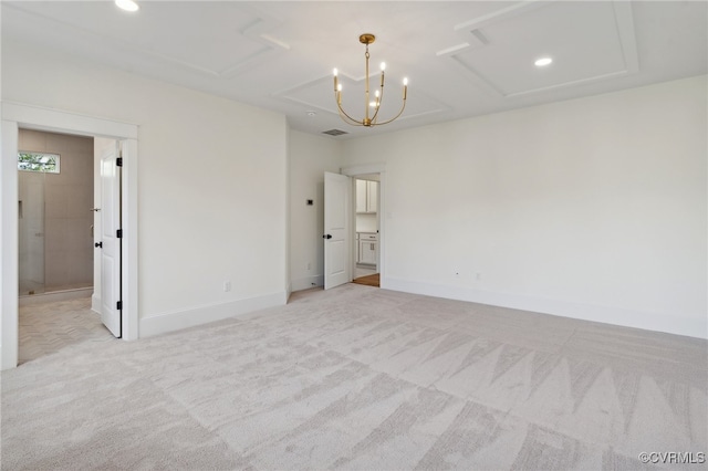 carpeted spare room featuring a chandelier