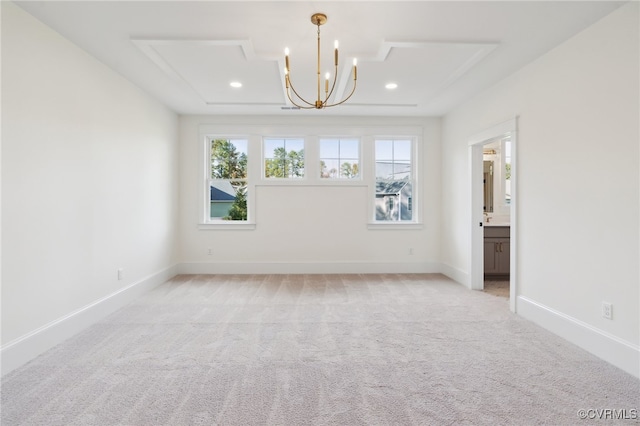 carpeted empty room with a notable chandelier