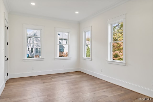 empty room featuring crown molding and light wood-type flooring