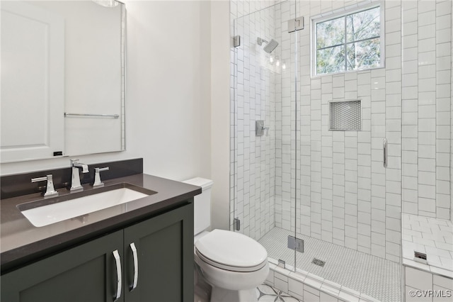 bathroom with vanity, toilet, tile patterned floors, and a shower with door