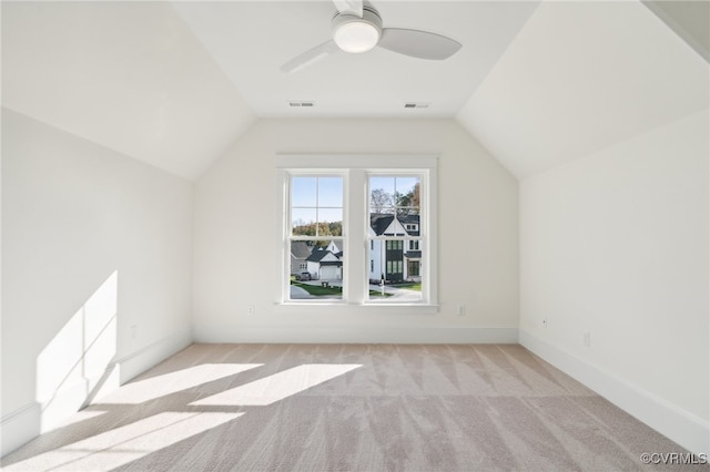 bonus room with vaulted ceiling and light colored carpet