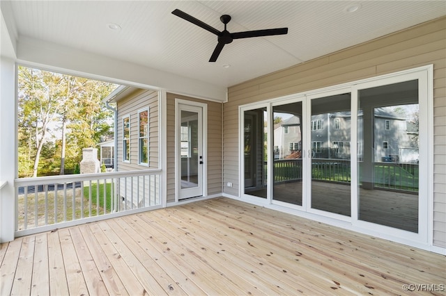 unfurnished sunroom featuring ceiling fan and a wealth of natural light