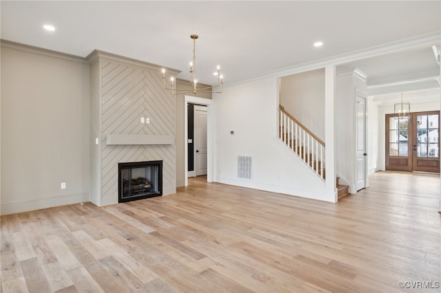 unfurnished living room featuring light hardwood / wood-style floors, crown molding, and a large fireplace