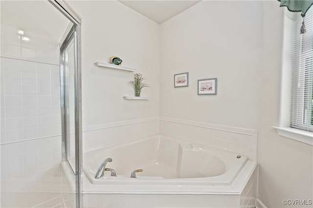 bathroom featuring shower with separate bathtub