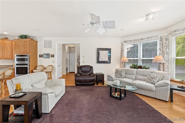 living room featuring light hardwood / wood-style floors and ceiling fan