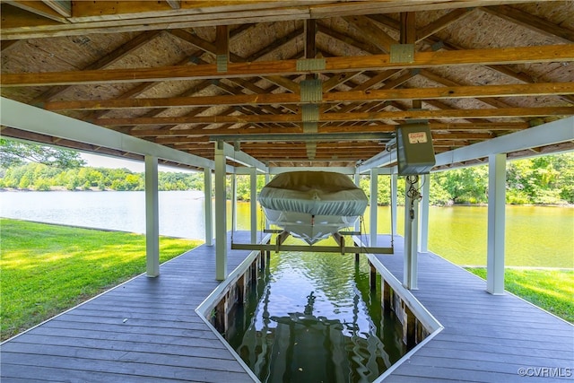 view of dock with a yard, a water view, and boat lift