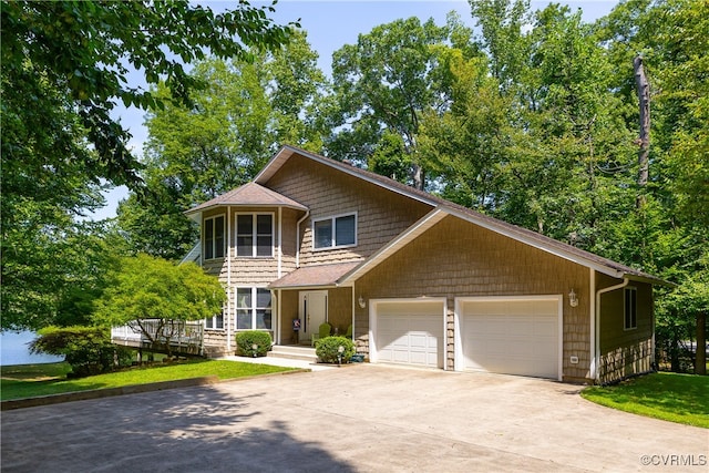 view of front facade with a front lawn, an attached garage, and driveway