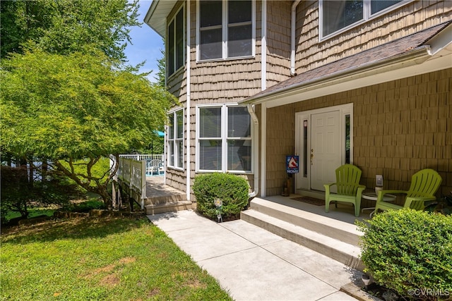 view of exterior entry with a yard