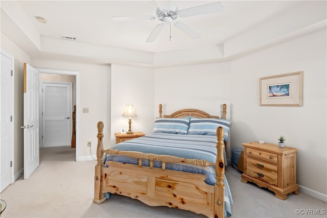 bedroom with visible vents, light colored carpet, baseboards, and ceiling fan