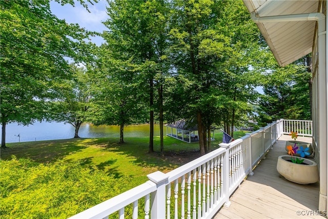 wooden deck featuring a lawn and a water view