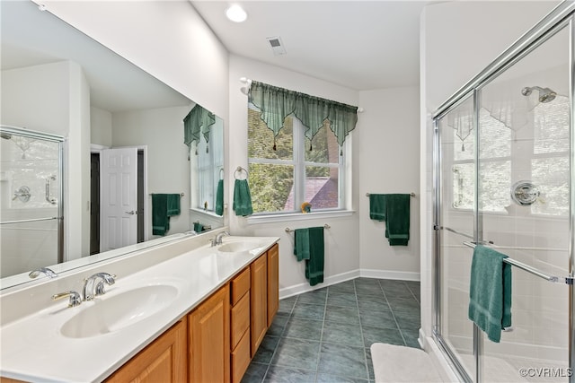 bathroom with vanity, plenty of natural light, tile patterned flooring, and a shower with shower door