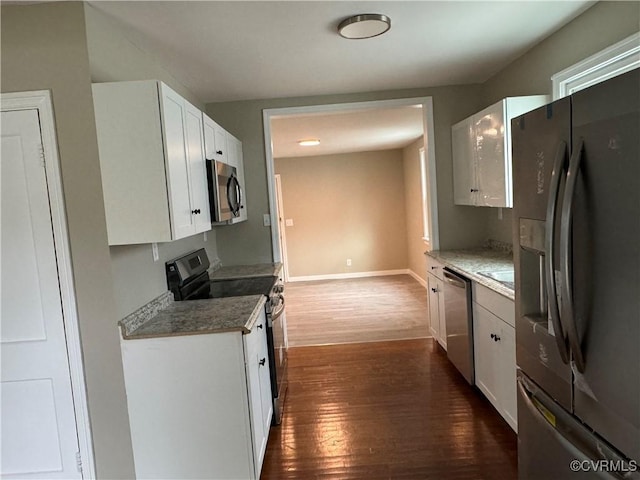 kitchen featuring dark wood finished floors, white cabinets, baseboards, and appliances with stainless steel finishes