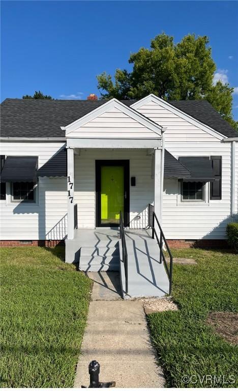 bungalow featuring a front yard, covered porch, and a shingled roof