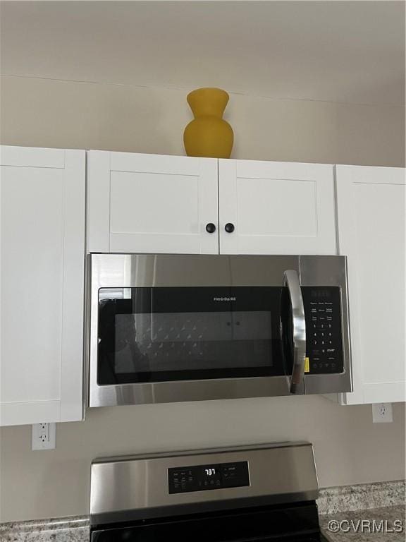 room details featuring light countertops, white cabinets, and stainless steel appliances