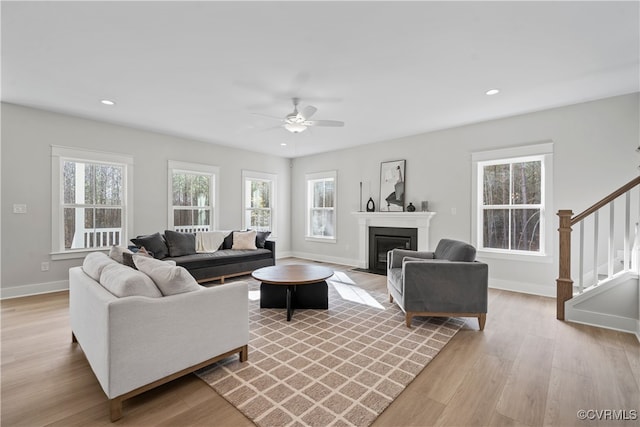 living room featuring ceiling fan and light hardwood / wood-style flooring