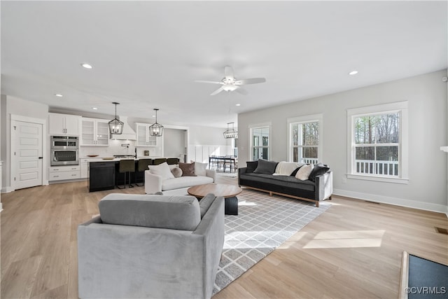 living room with light wood-type flooring and ceiling fan