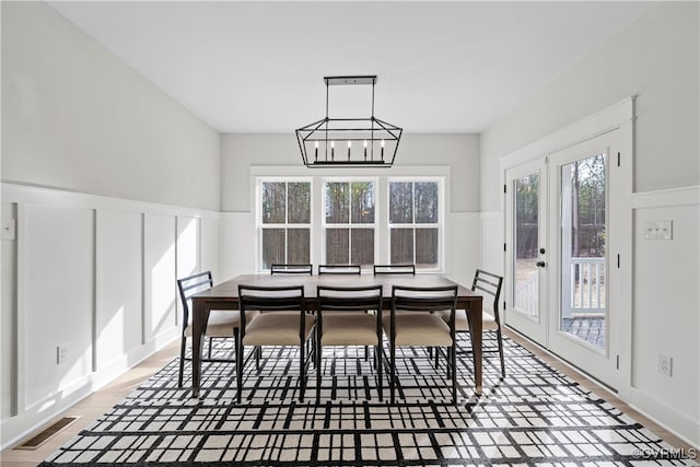 dining area with hardwood / wood-style floors and a chandelier