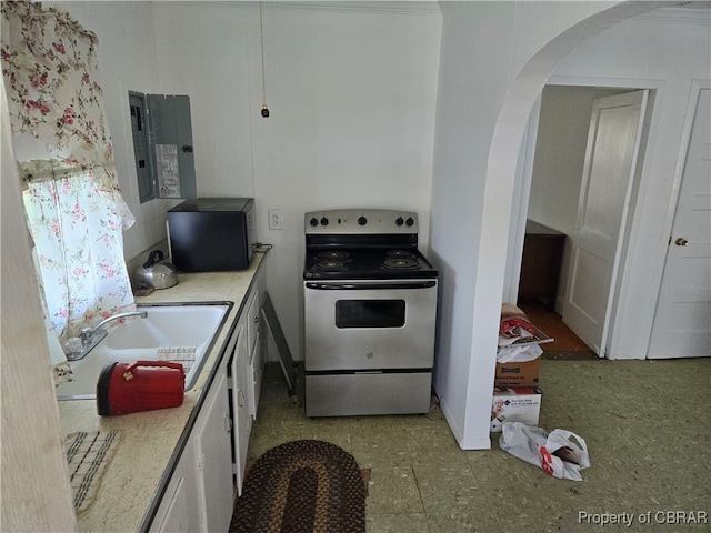 kitchen featuring electric range oven, light tile patterned flooring, and white cabinetry