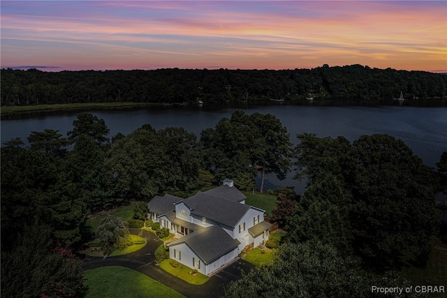 aerial view at dusk featuring a water view