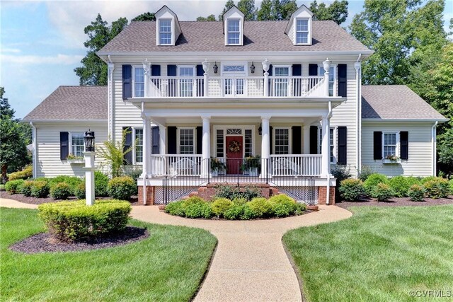 view of front of property featuring a balcony, covered porch, and a front yard