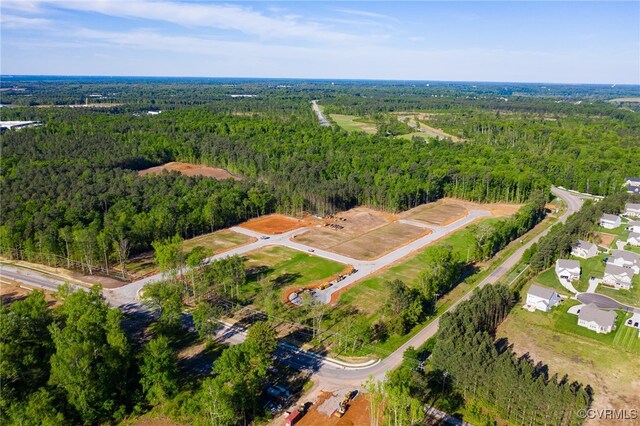 bird's eye view with a wooded view