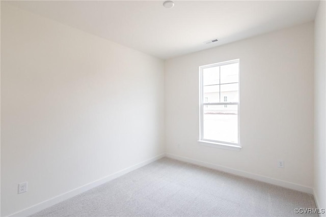 unfurnished room featuring light colored carpet, visible vents, and baseboards