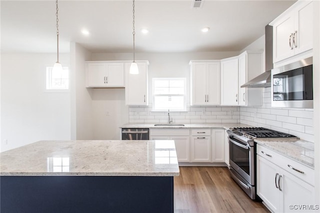 kitchen with tasteful backsplash, stainless steel appliances, light wood-style floors, white cabinetry, and a sink