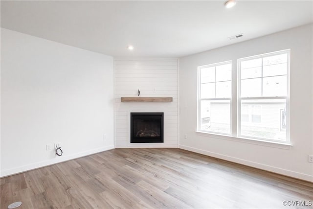 unfurnished living room with recessed lighting, a fireplace, wood finished floors, visible vents, and baseboards