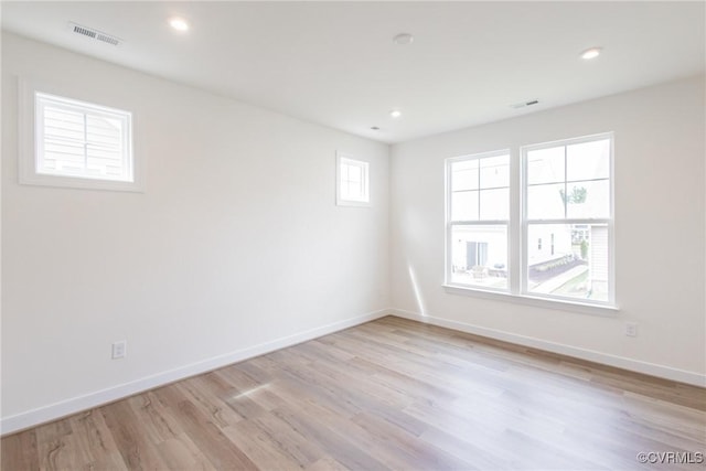 empty room featuring recessed lighting, visible vents, light wood finished floors, and baseboards