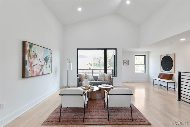 living room featuring light hardwood / wood-style floors and high vaulted ceiling