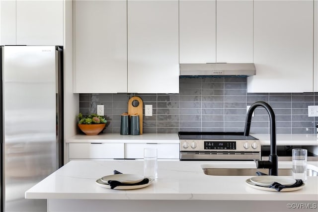 kitchen featuring stainless steel appliances, white cabinetry, tasteful backsplash, and light stone counters