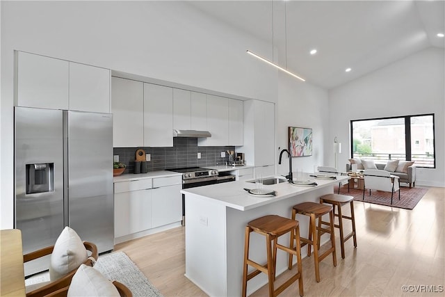 kitchen with white cabinets, sink, an island with sink, and stainless steel appliances