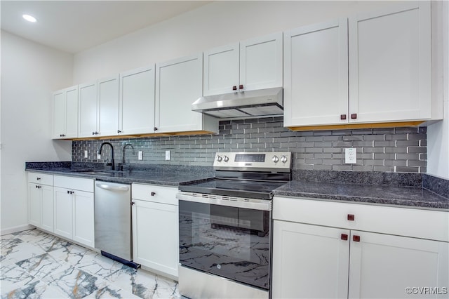 kitchen with white cabinets, stainless steel appliances, dark stone counters, and tasteful backsplash