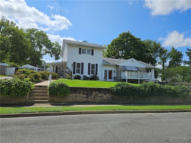 view of front of home with a front lawn and a balcony