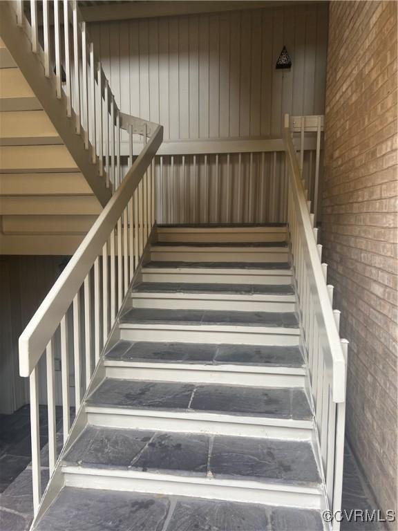 staircase featuring brick wall