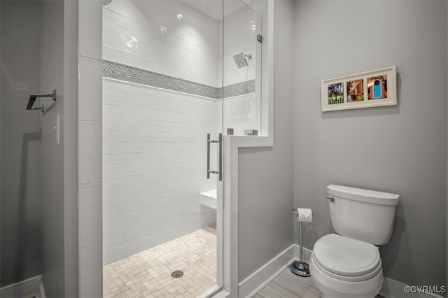 bathroom featuring toilet and an enclosed shower