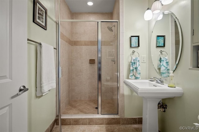 bathroom with a shower with shower door and tile patterned floors