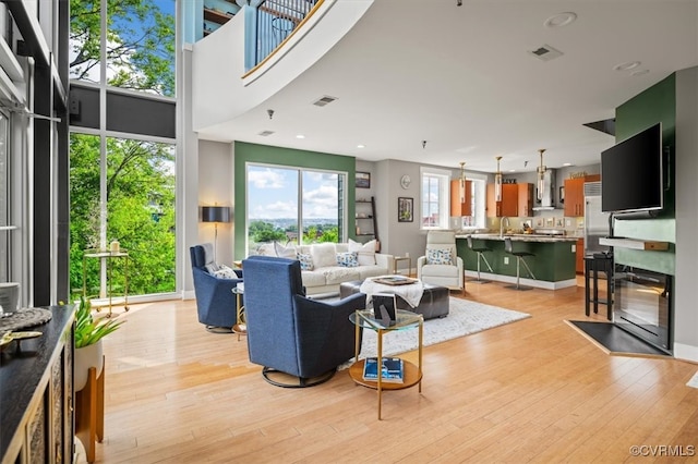 living room featuring a wealth of natural light, light hardwood / wood-style flooring, and sink