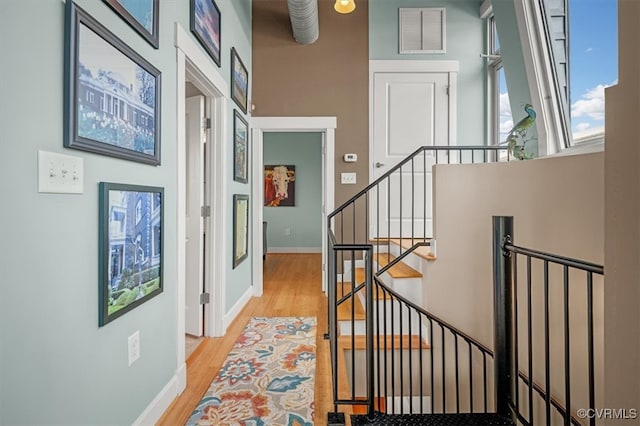 stairs featuring hardwood / wood-style flooring and a towering ceiling