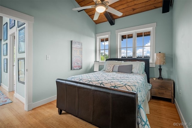 bedroom with light wood-type flooring, wooden ceiling, ceiling fan, and vaulted ceiling with beams