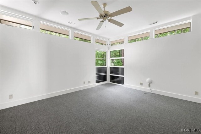 carpeted empty room with ceiling fan and a healthy amount of sunlight