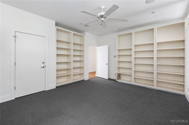 interior space with dark colored carpet and ceiling fan