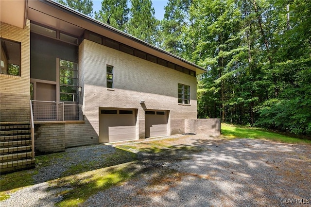 view of home's exterior with brick siding, driveway, and a garage
