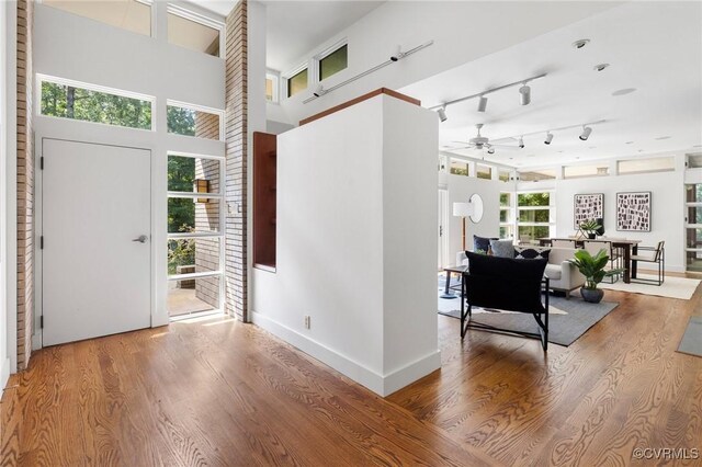 entrance foyer with a towering ceiling, ceiling fan, and hardwood / wood-style flooring