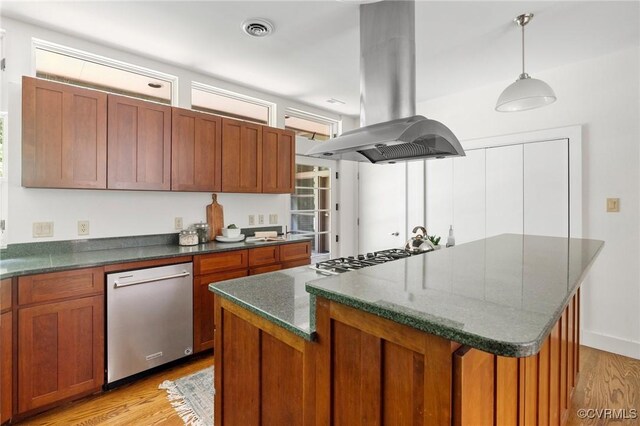 kitchen with island range hood, hanging light fixtures, a kitchen island, light hardwood / wood-style flooring, and appliances with stainless steel finishes