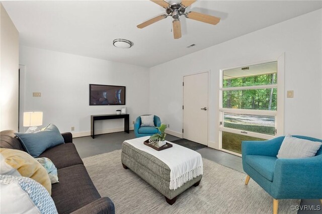 living room with ceiling fan and concrete floors