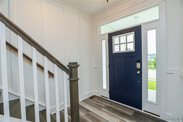 foyer with a wealth of natural light, crown molding, and wood-type flooring