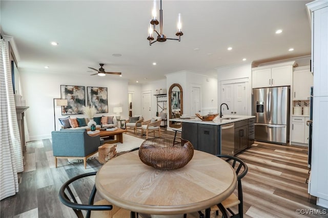 dining space with recessed lighting, light wood-type flooring, and ornamental molding