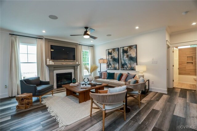 living room with dark hardwood / wood-style flooring, ceiling fan, a high end fireplace, and a healthy amount of sunlight