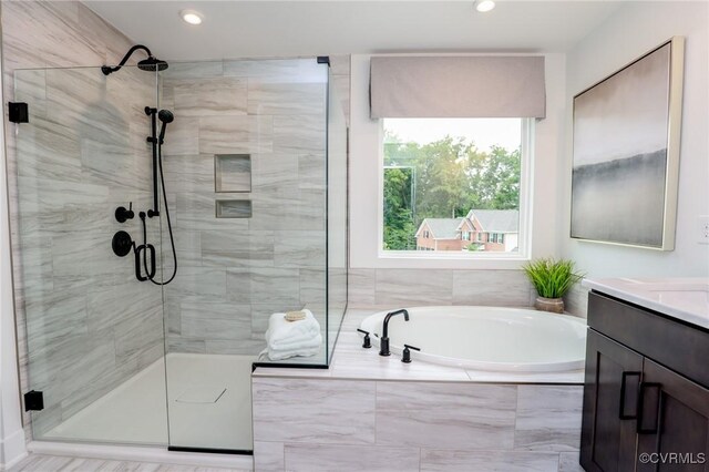 bathroom with independent shower and bath and vanity